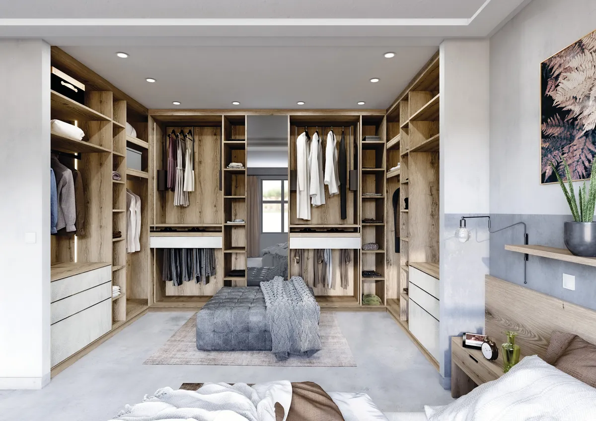 Aménagement de dressing en U ouvert sur mesure en bois clair avec tiroirs blancs et îlot central capitonné.