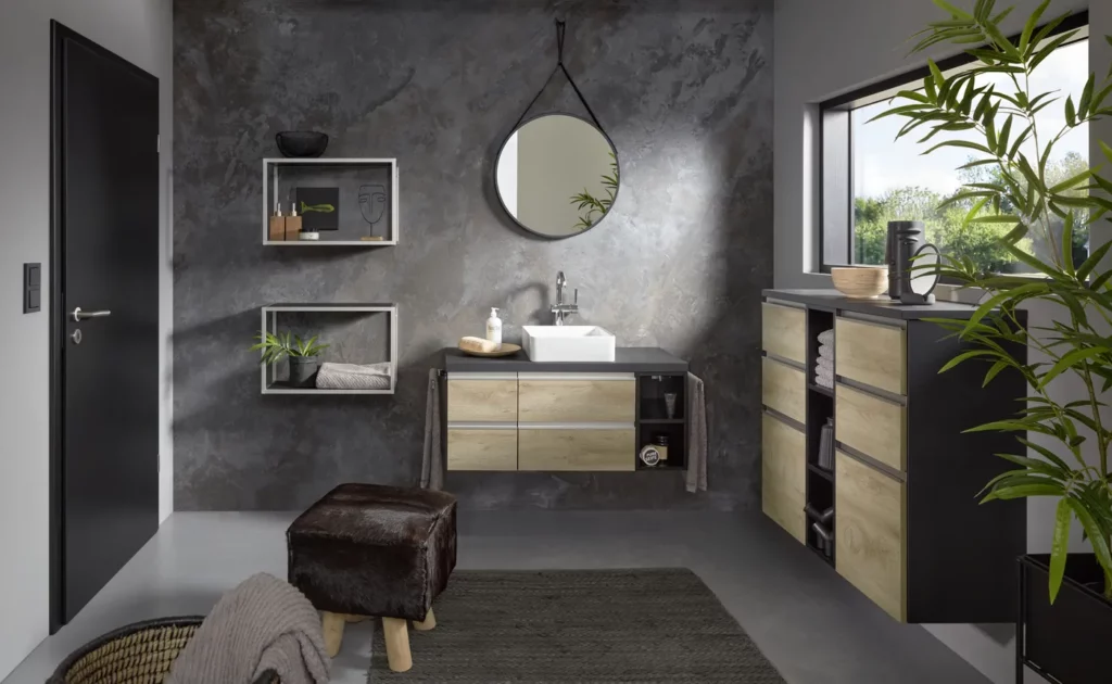 Salle de bain industrielle bois et noir : Aménagement avec meuble vasque en chêne, étagères murales noires et accessoires de décoration modernes.