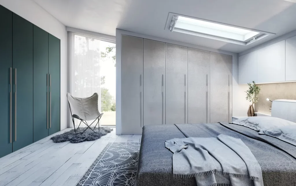 Suite parentale avec dressing sous pente : Chambre spacieuse sous les toits avec placards sur mesure gris bleuté et coin bureau minimaliste.