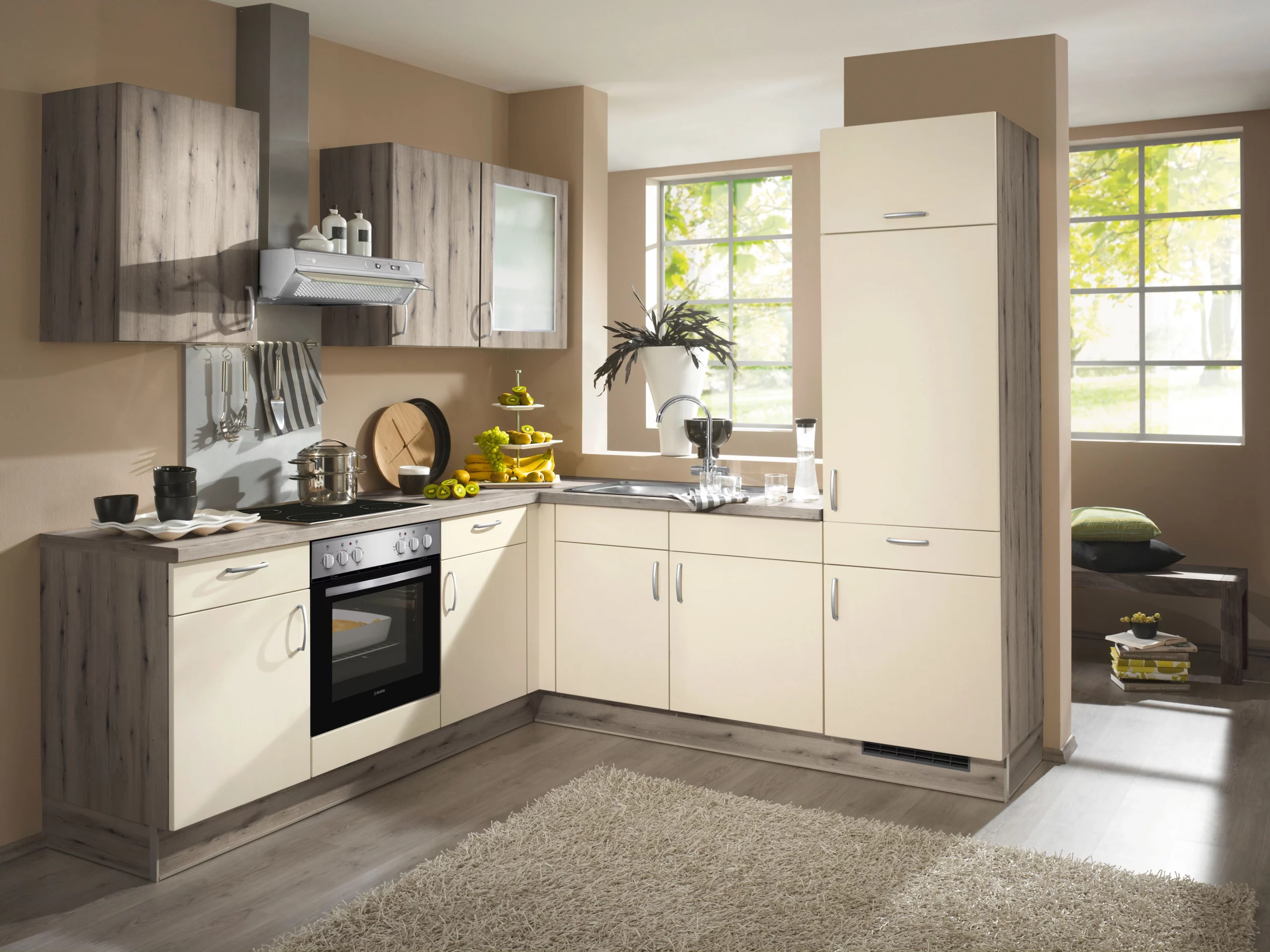 Petite cuisine d'angle moderne beige et bois gris avec hotte aspirante en inox et tapis de cuisine gris.