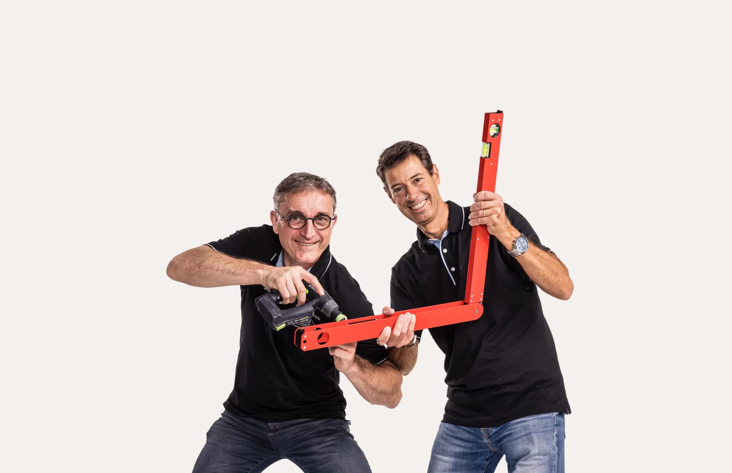 Installation technique de précision : Deux installateurs Venidom utilisant un niveau laser rouge et une perceuse pour une pose de cuisine parfaite.