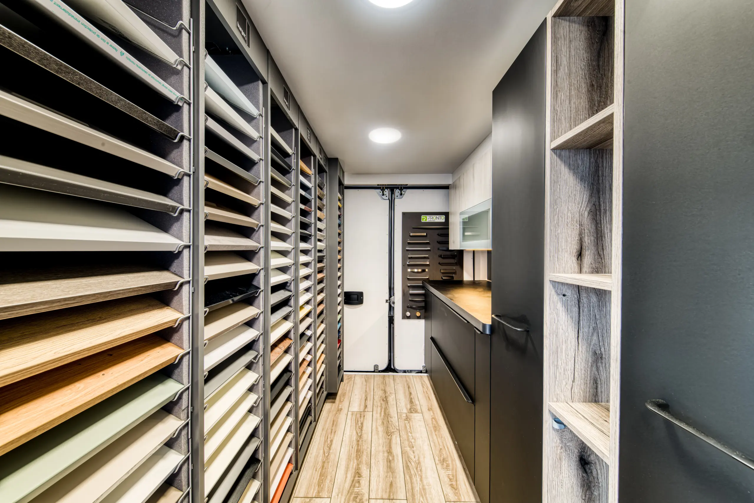 Intérieur du camion Venidom : Vue des présentoirs d'échantillons de façades et de plans de travail à l'intérieur du camion-magasin.