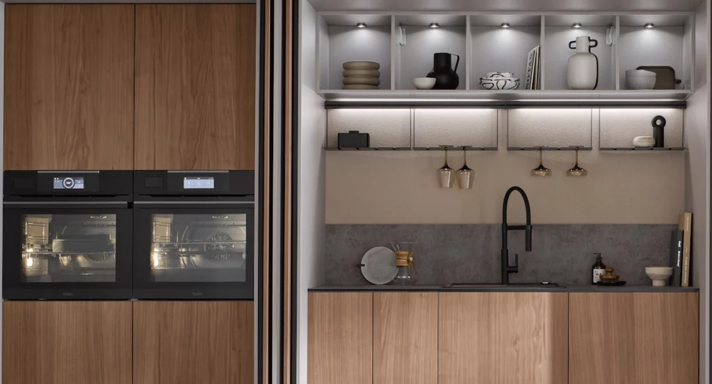 Cuisine blanche avec meubles hauts vitrés, îlot central prolongé par un bar en bois sombre et tabourets hauts.