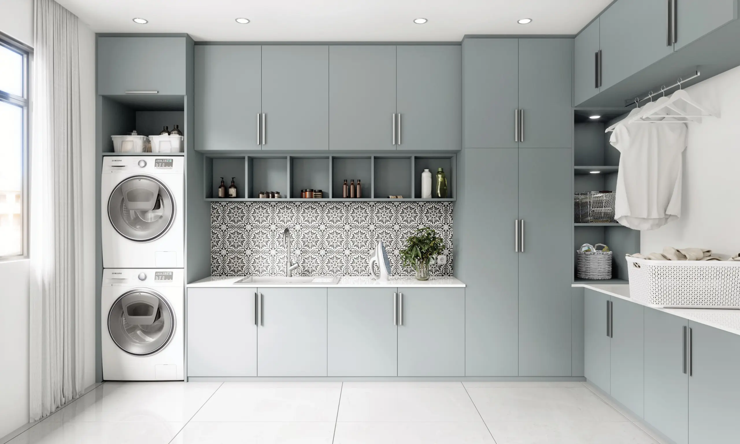 Grande buanderie moderne bleu-gris mat avec colonnes pour lave-linge et sèche-linge superposés et crédence graphique.