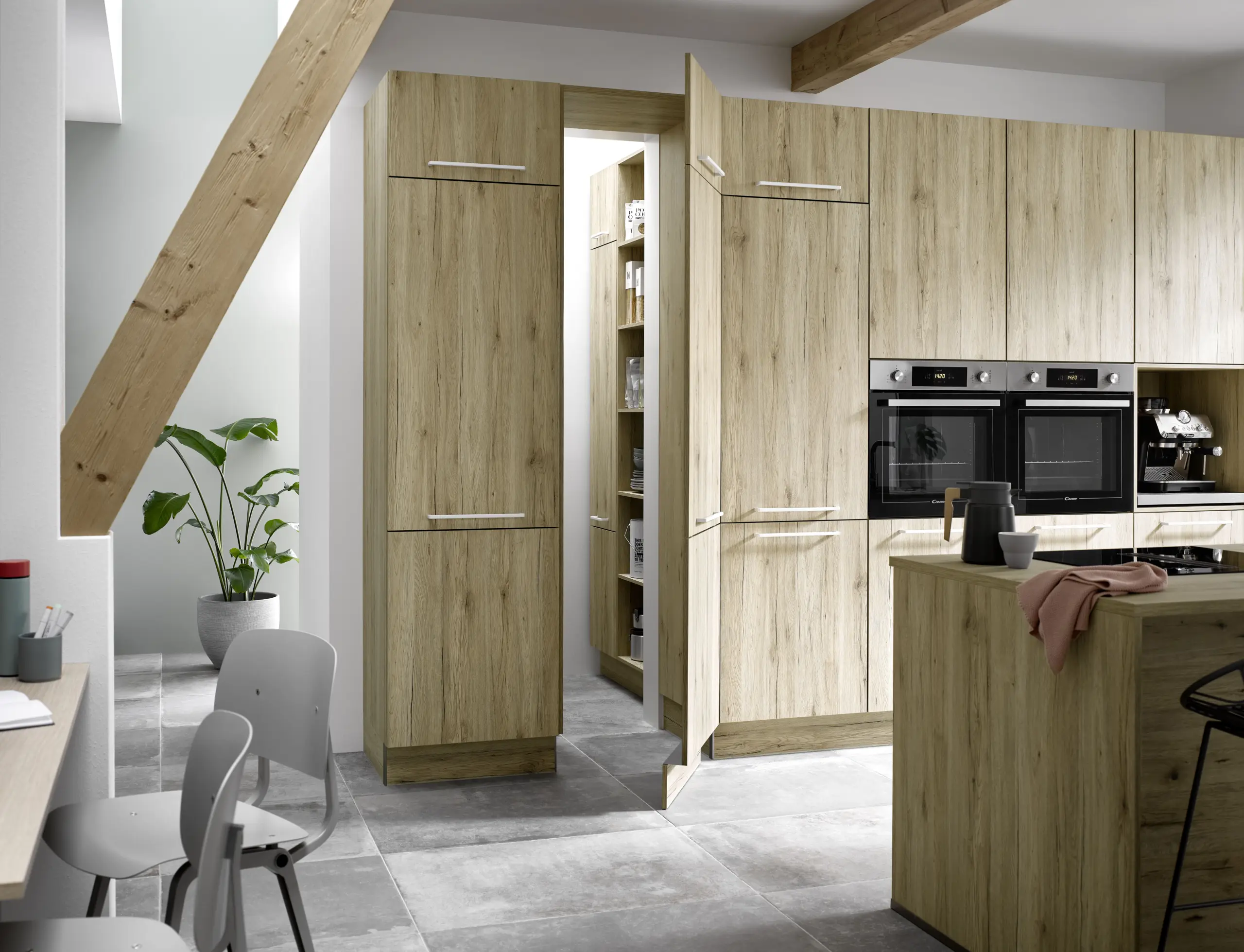 Cuisine moderne en bois clair avec porte de cellier invisible intégrée dans les armoires.