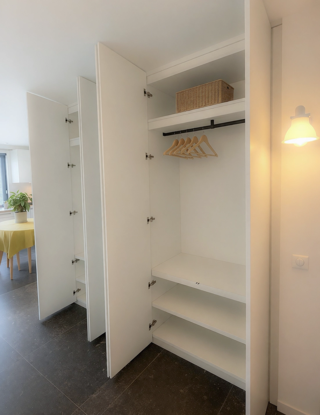 Aménagement intérieur de placard sur mesure avec étagères, penderie et rangements fonctionnels dans un espace de passage lumineux et contemporain