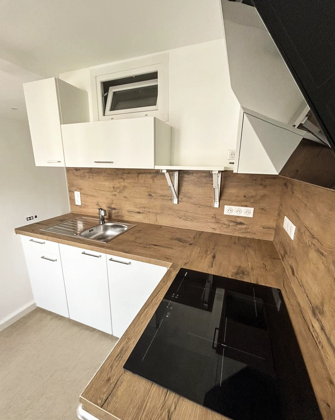 Aménagement de petite cuisine sur mesure avec meubles hauts, plan de travail bois et implantation optimisée pour une circulation fluide