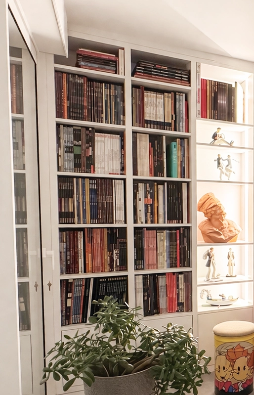 Détail de bibliothèque sur mesure avec niches lumineuses mettant en valeur objets décoratifs et livres dans un salon chaleureux et structuré