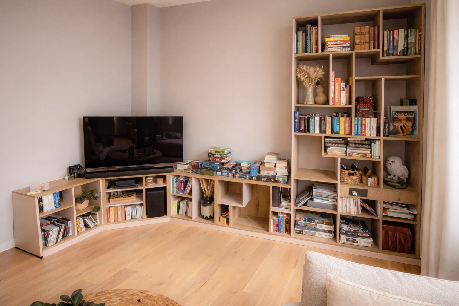 Bibliothèque sur mesure en angle dans un salon avec meuble TV intégré et rangements ouverts en bois pour livres et objets