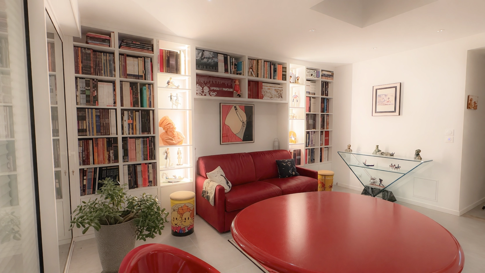 Bibliothèque sur mesure toute hauteur dans un salon moderne avec rangements pour livres et niches décoratives éclairées autour d’un canapé