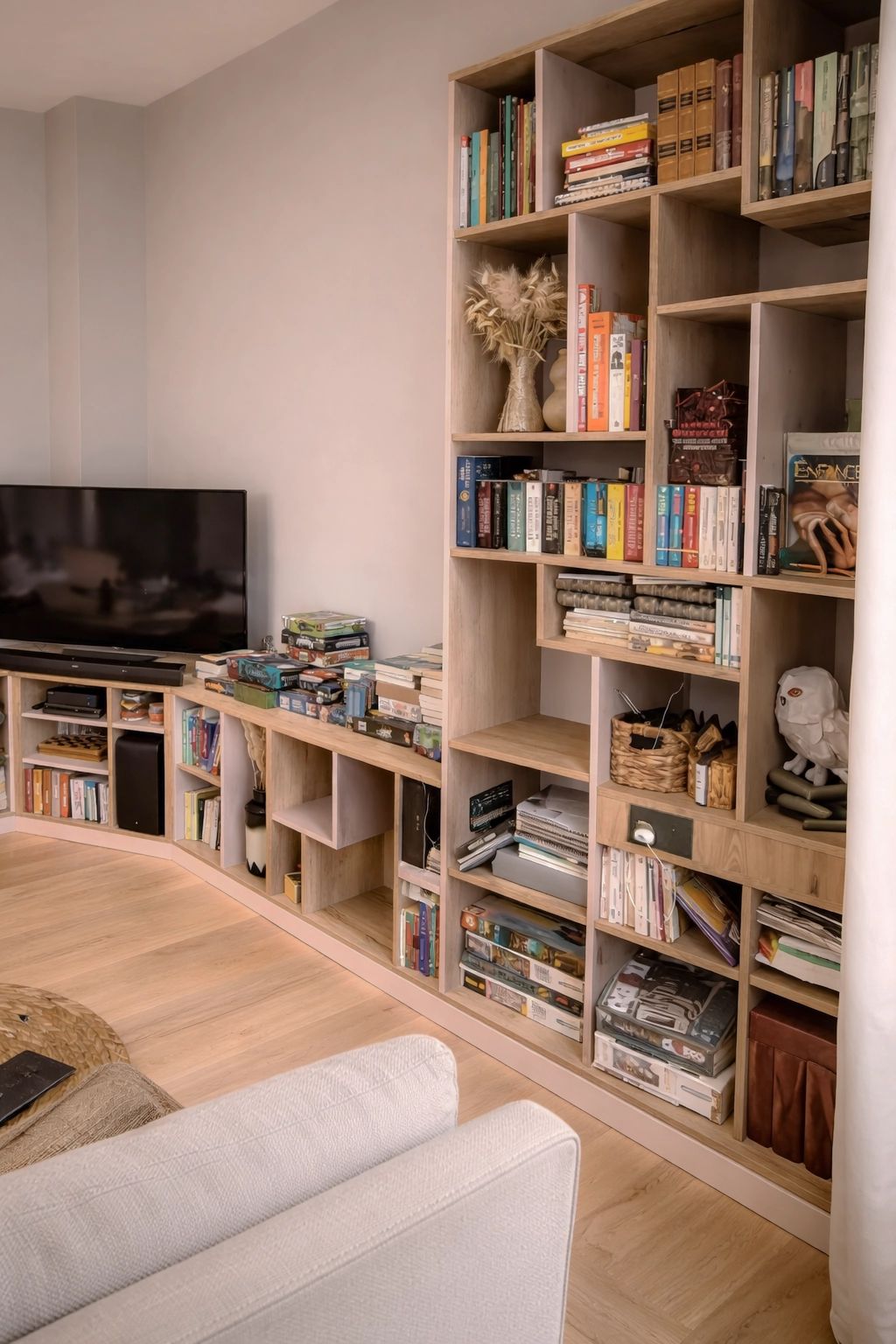 Détail de bibliothèque sur mesure en bois avec niches ouvertes et rangements optimisés pour livres et objets décoratifs dans un salon moderne