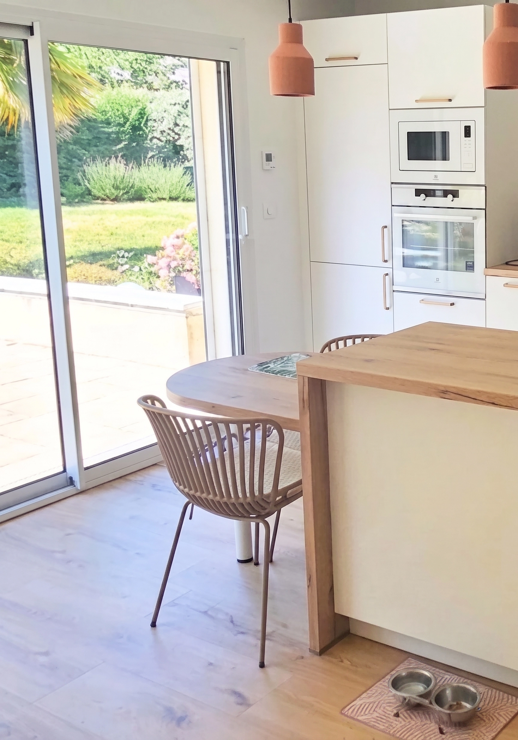 Zoom sur les meubles colonnes toute hauteur d'une cuisine Venidom, intégrant le four et le micro-ondes pour un gain de place optimal et une esthétique épurée.