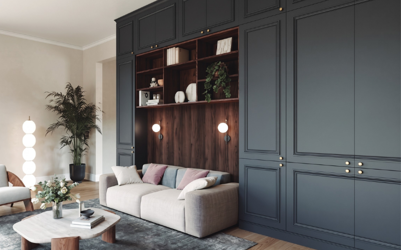 Salon moderne avec grand meuble sur mesure bleu nuit intégrant une niche en bois, des appliques murales douces et un canapé d'angle deux places éloigné des parois froides.